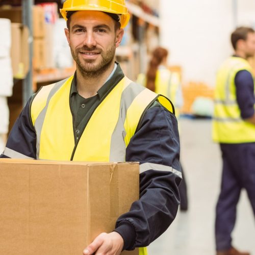 man carrying a box in a warehouse